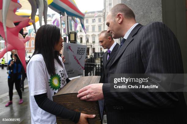 Greenpeace protestors hand over signed petitions to door staff at the BP headquarters during a protest parade in St. Jame's Square on August 21, 2017...