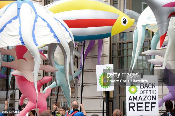 Greenpeace protestors hold the inflatable sea creatures up to the windows of the BP headquarters after delivering petitions during a protest in St....
