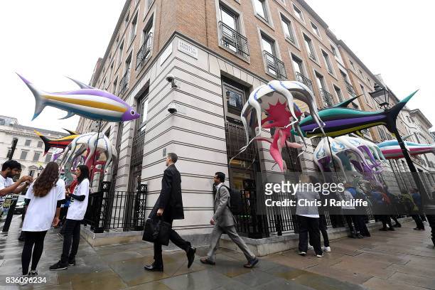 Greenpeace protestors hold the inflatable sea creatures up to the windows of the BP headquarters after delivering petitions during a protest in St....