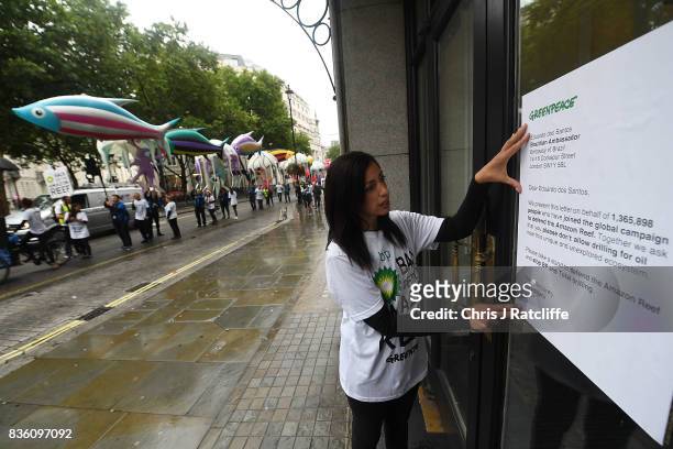 Greenpeace protestor attaches a letter to the window of the Brazilian embassy during a parade of inflatable sea creatures protest on August 21, 2017...