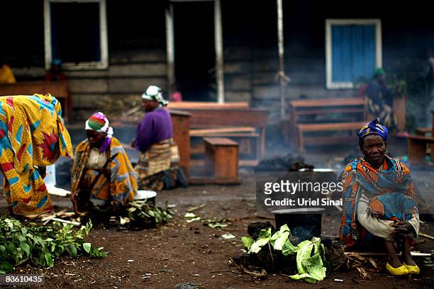 Women cook at the Kibati refugee camp on November 08, 2008 on the outskirts of Goma, eastern Democratic Republic of Congo. Over 250,000 people have...