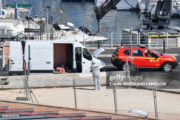 French forensic police officers search a vehicle following a car crash in the southern Mediterranean city of Marseille on August 21, 2017. - At least...