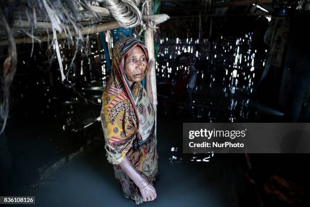 Woman stands high-deep in flood water inside her submarged house in Guthail, Jamalpur, Bangladesh, on 19 August 2017.