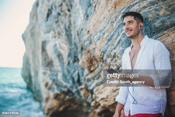 relaxing by the sea alone - mens swimwear stock pictures, royalty-free photos & images