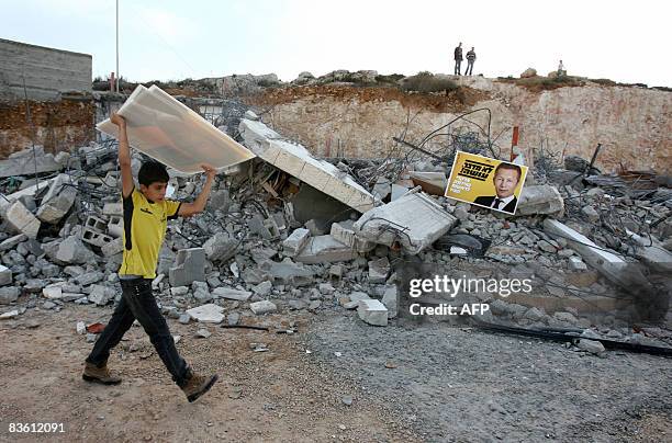 Palestinian boy carries campaign posters of Israeli-Russian billionaire Arkady Gaydamak, who is standing for mayor in the up-coming Jerusalem...