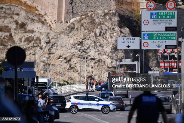 French forensic police officers and security personnel gather near a vehicle following a car crash in the southern Mediterranean city of Marseille on...