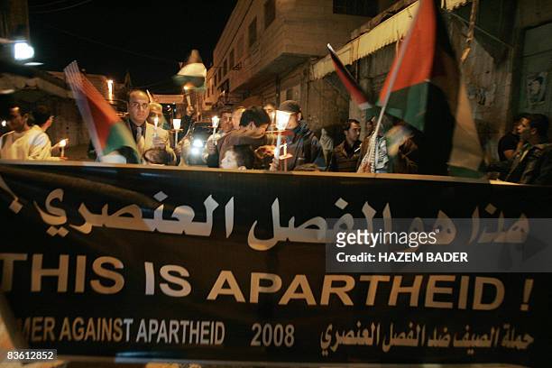 Palestinians and foreign peace activists join a candle light protest against settlers' violence and the Israeli closure of the Old City of Hebron on...