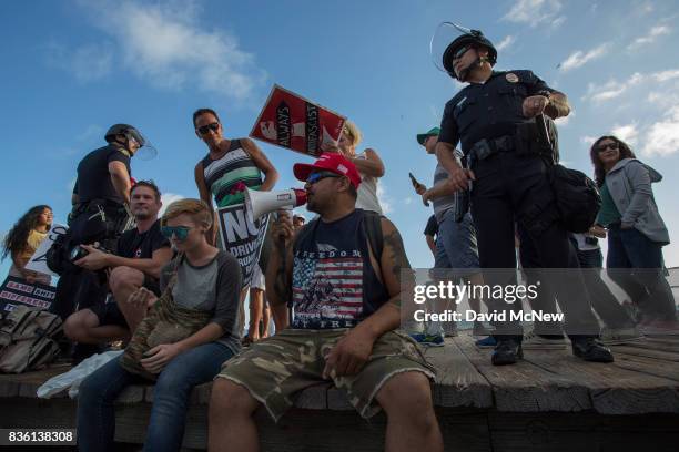 Conservative demonstrators rally as police form a line to keep them from clashing with counter demonstrators during an 'America First' demonstration...