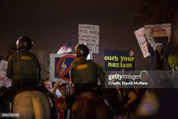 Sheriff deputies on horseback form a line to keep demonstrators and counter demonstrators apart during an 'America First' demonstration on August 20,...