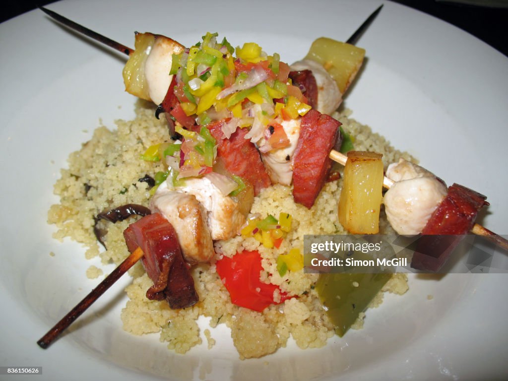 Grilled ham, chicken and pineapple skewers served with couscous and salsa