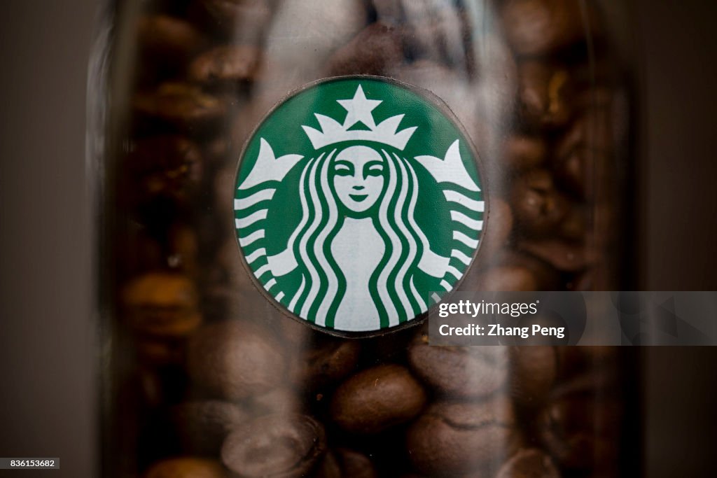 Coffee beans and Starbucks logo, arranged for photography.