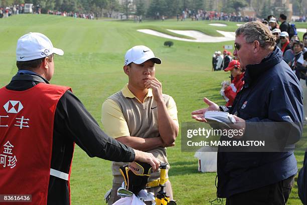 Anthony Kim of the US talks with an unidentified official after being disqualified from the event due to a club violation in the third round of the...