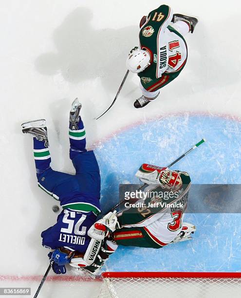 Michel Ouellet of the Vancouver Canucks collides with goaltender Niklas Backstrom of the Minnesota Wild as Martin Skoula of the Wild looks on during...