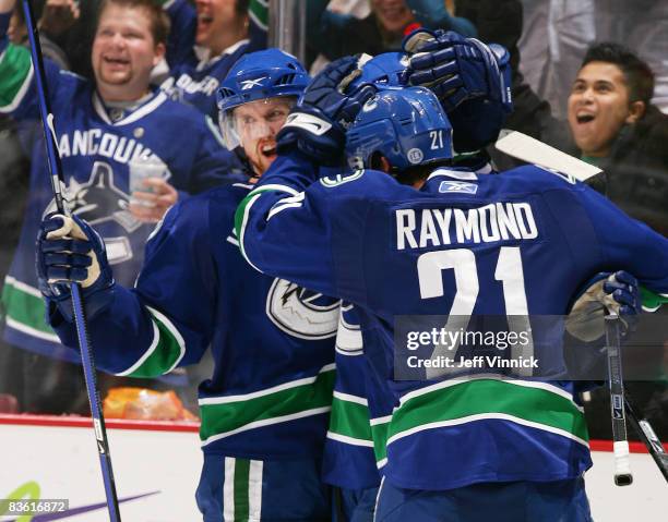 Daniel Sedin of the Vancouver Canucks is congratulated by teammate Mason Raymond after scoring during their game against the Minnesota Wild at...