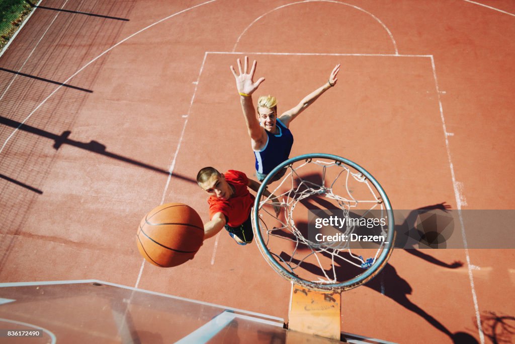 Young men playing basketball one on one