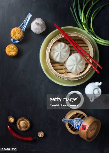 flat lay chinese food and drink on moody rustic table top. - chinese steamed bun stock-fotos und bilder