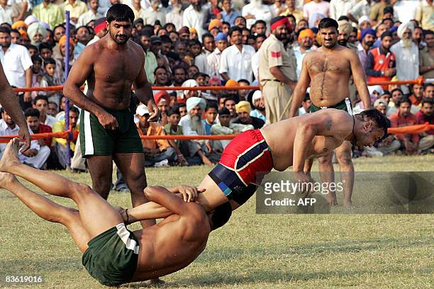An Indian kabbadi player is tackled by his Pakistani opponent during the 2008 Sri Guru Gobind Singh Kabaddi Series in Gopalpur Majwind village, some...