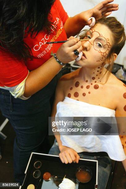 Model gets her body painted during the 'Xocolating' chocolate fair in Barcelona on November 9, 2008. AFP PHOTO / JOSEP LAGO