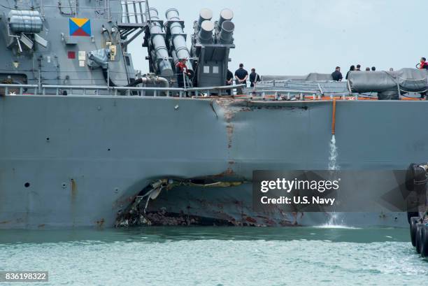 In this released U.S. Navy handout, damage to the portside is visible as the Guided-missile destroyer USS John S. McCain steers towards Changi Naval...