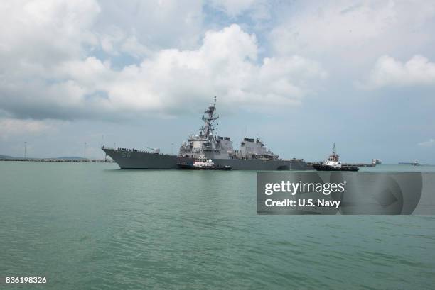 In this released U.S. Navy handout, tugboats from Singapore assist the Guided-missile destroyer USS John S. McCain at it steers towards Changi Naval...