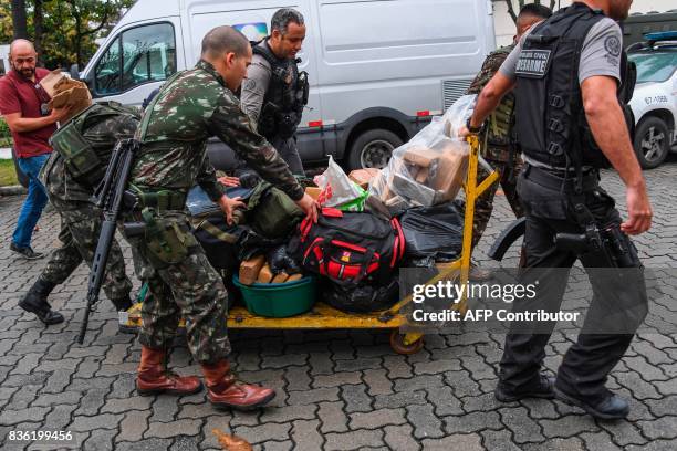 Militaries and police officers arrive at the Cidade da Policia Civil police complex with drugs seized during a pre-dawn crackdown on crime gangs at...
