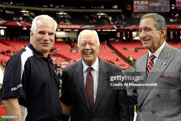 Former US President Jimmy Carter poses with Atlanta Falcons owner Arthur Blank and coach Mike Smith before the game between the New Orleans Saints...