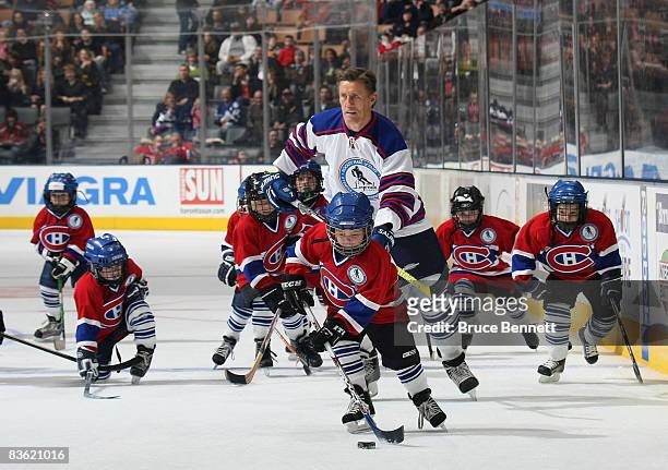 Borje Salming of the All Star Legends is surrounded by youth players sporting Montreal Canadien jerseys at the Legends Classic Game on November 9,...