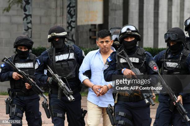 Members of the Honduran elite police unit Tigres escort Sergio Neptali Mejia Duarte , wanted in the US for alleged drug trafficking, in Tegucigalpa...