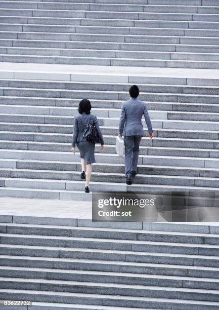 man and woman on business going up the stairs,rear - japanese tree stockfoto's en -beelden