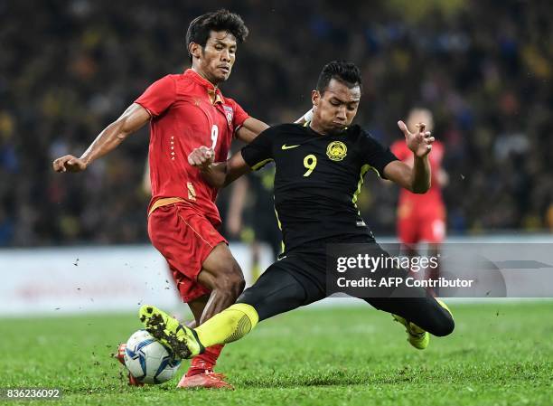 Malaysia's Nor Azam Azlin fights for the ball with Myanmar's Aung Thu during their men's football match at the 29th Southeast Asian Games at Shah...