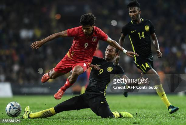 Malaysia's Nor Azam Azlin fights for the ball with Myanmar's Aung Thu during their men's football match at the 29th Southeast Asian Games at Shah...