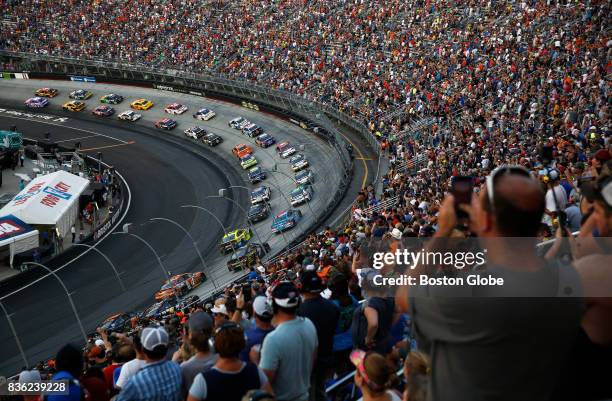 Fans watch as the cars take a lap before the start of the Bass Pro Shops NRA Night Race at the Bristol Motor Speedway in Bristol, TN on Aug. 19, 2017.