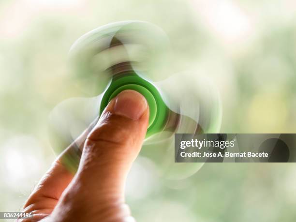 young boy playing with fidget spinner toy to relieve stress outdoor. spain - fidget spinner stock-fotos und bilder