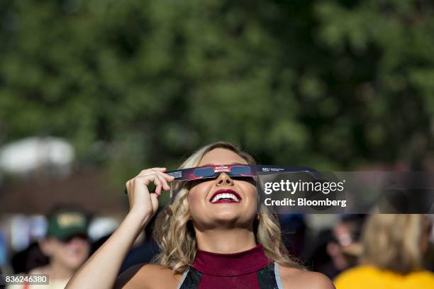 Cheerleader tests out a pair of solar viewing glasses during a eclipse viewing event on the campus of Southern Illinois University in Carbondale,...