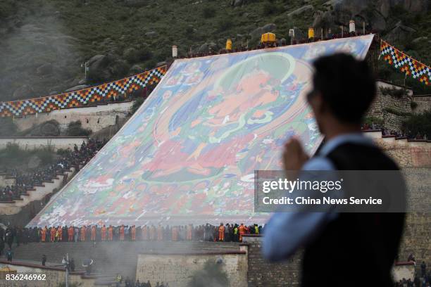 Local residents and tourists worship a large thangka during the Sho Dun Festival at Drepung Monastery on August 21, 2017 in Lhasa, China. The Sho Dun...