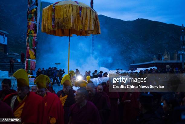 Tibetan buddhist monks carry a large thangka to display during the Sho Dun Festival at Drepung Monastery on August 21, 2017 in Lhasa, China. The Sho...