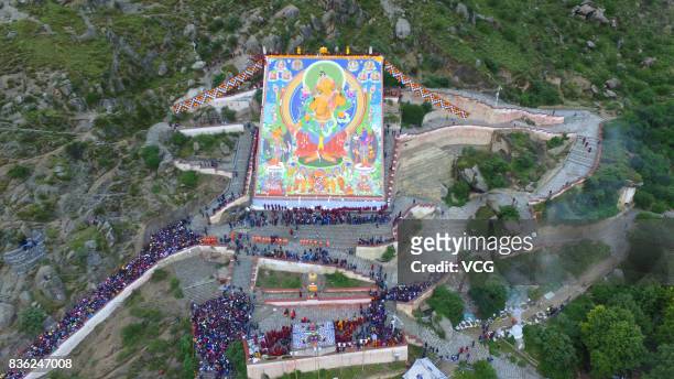 Local residents and tourists worship a large thangka during the Sho Dun Festival at Drepung Monastery on August 21, 2017 in Lhasa, China. The Sho Dun...