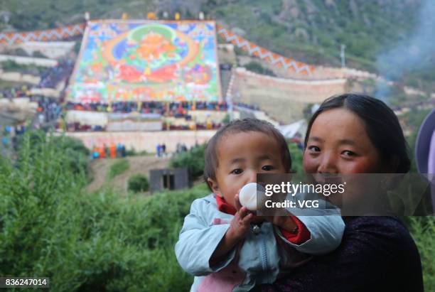 Local residents and tourists worship a large thangka during the Sho Dun Festival at Drepung Monastery on August 21, 2017 in Lhasa, China. The Sho Dun...