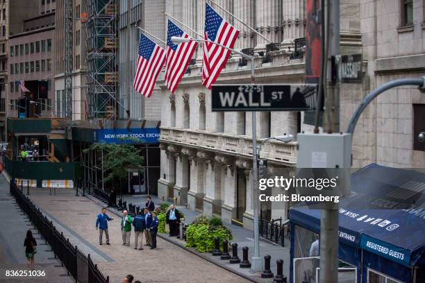 Traders stand in front of the New York Stock Exchange in New York, U.S., on Monday, Aug. 21, 2017. U.S. Stocks fluctuated after erasing early losses,...