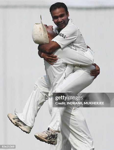 Indian cricketer Amit Mishra celebrates with teammate Harbhajan Singh after taking the wicket of Australian cricketer Brad Haddin on the fifth and...