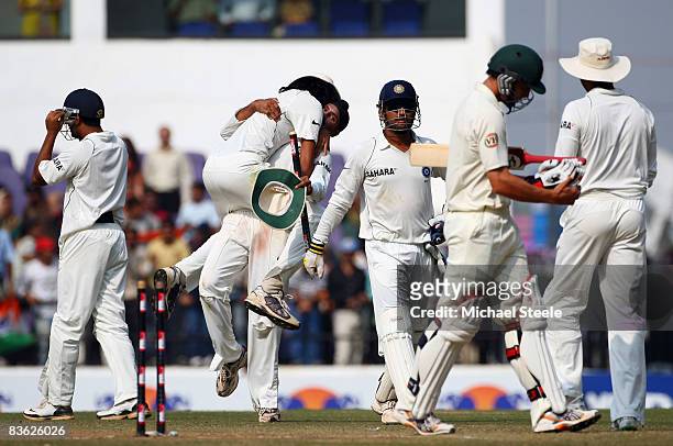 Mitchell Johnson of Australia walks off after being dismissed as Harbhajan Singh of India celebrates with Ishant Sharma of India during day five of...