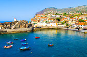 View of Camara de Lobos port with colourful fishing boats on sea, Madeira island