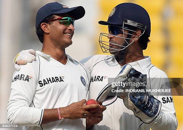 Indian cricketer Mahendra Singh Dhoni speaks to teammate Sourav Ganguly during the final test match of the Border-Gavaskar Trophy 2008 at the...