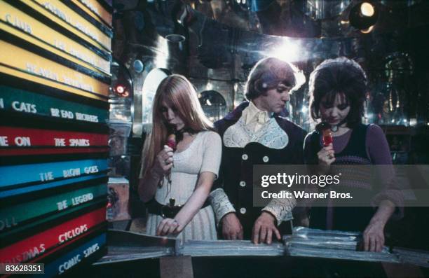 British actor Malcolm McDowell meets two girls in a record store in a scene from 'A Clockwork Orange', 1971.