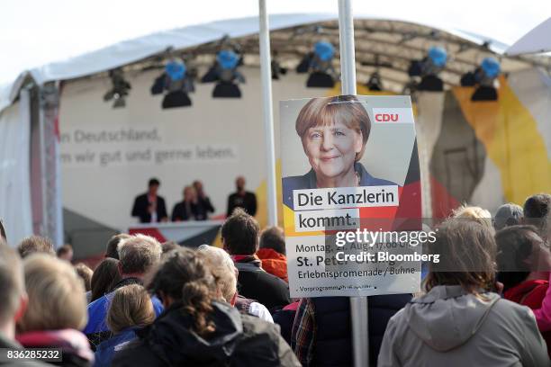 An attendee holds a sign displaying the image of Angela Merkel, Germany's chancellor and Christian Democratic Union leader, during an election...