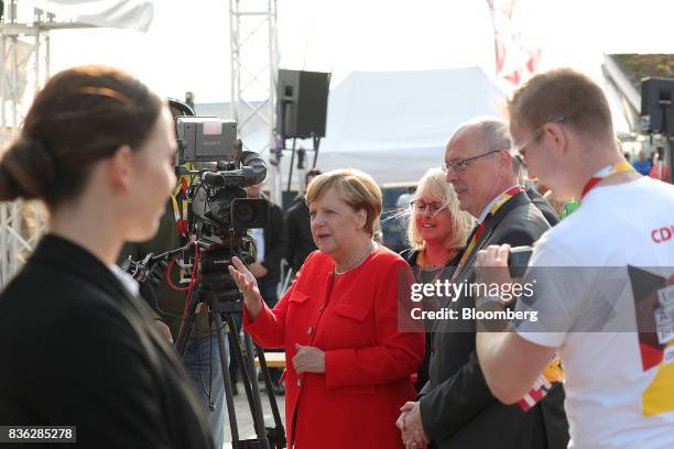 Angela Merkel, Germany's chancellor and Christian Democratic Union leader, speaks with attendees during an election campaign stop in Saint...