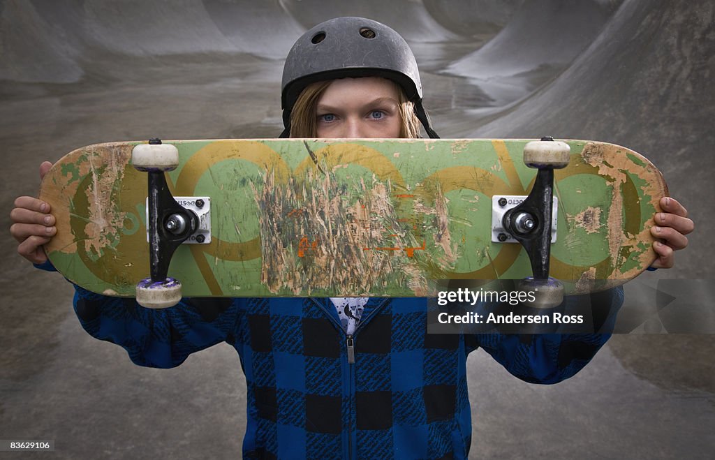 Portrait of young boy at a skate park with a skate