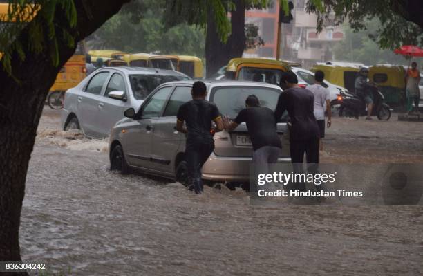 People pushing car as it broke down due to water-logging after heavy rains at sector 41 on August 21 2017 in Chandigarh, India. Heavy rainfall on...