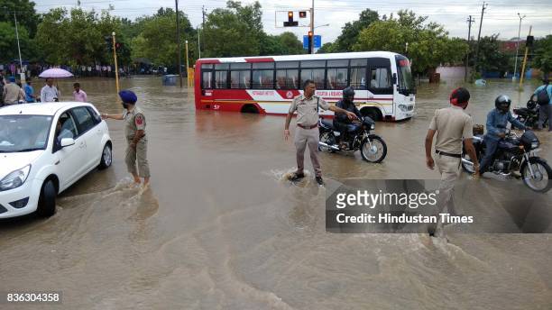 Policemen try to manage traffic due to waterlogging in sector 44-50 dividing after the heavy rain on August 21, 2017 in Chandigarh, India. Heavy...