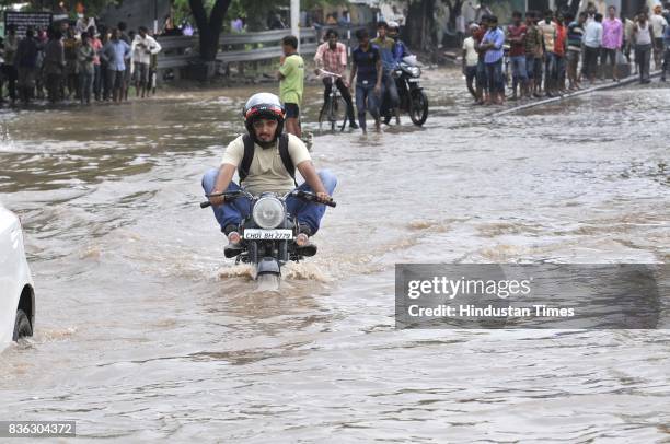 Biker raises his legs as he drives on waterlogged road of sector 44-50 dividing after the heavy rain on August 21, 2017 in Chandigarh, India. Heavy...